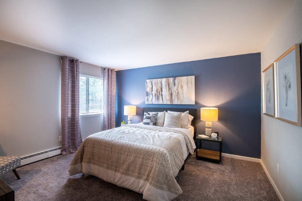 a bedroom with a bed and a blue accent wall