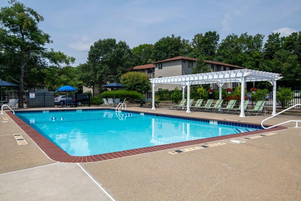 a resort style pool with a white pavilion and chairs around it