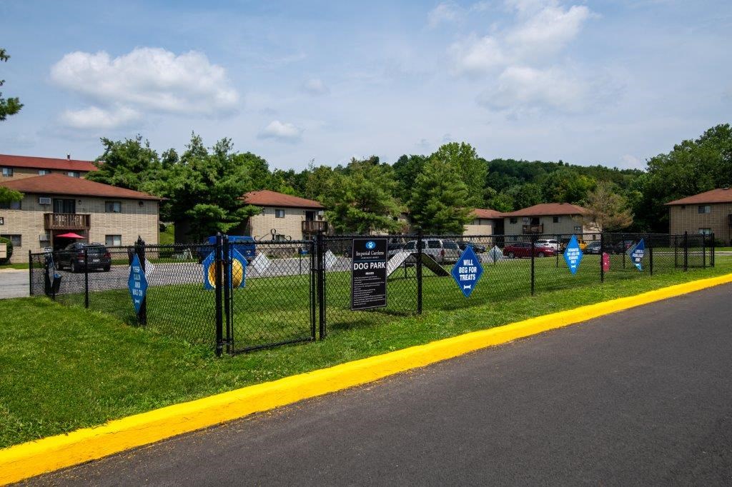 a fence with blue flags on it on the side of a street