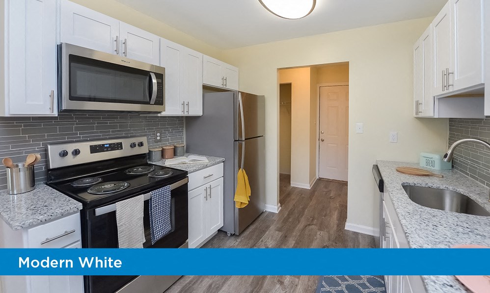 a modern white kitchen with a stove and a refrigerator
