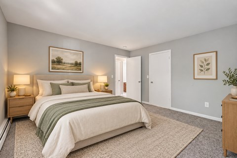 A bedroom with a bed, nightstands, and a painting on the wall.