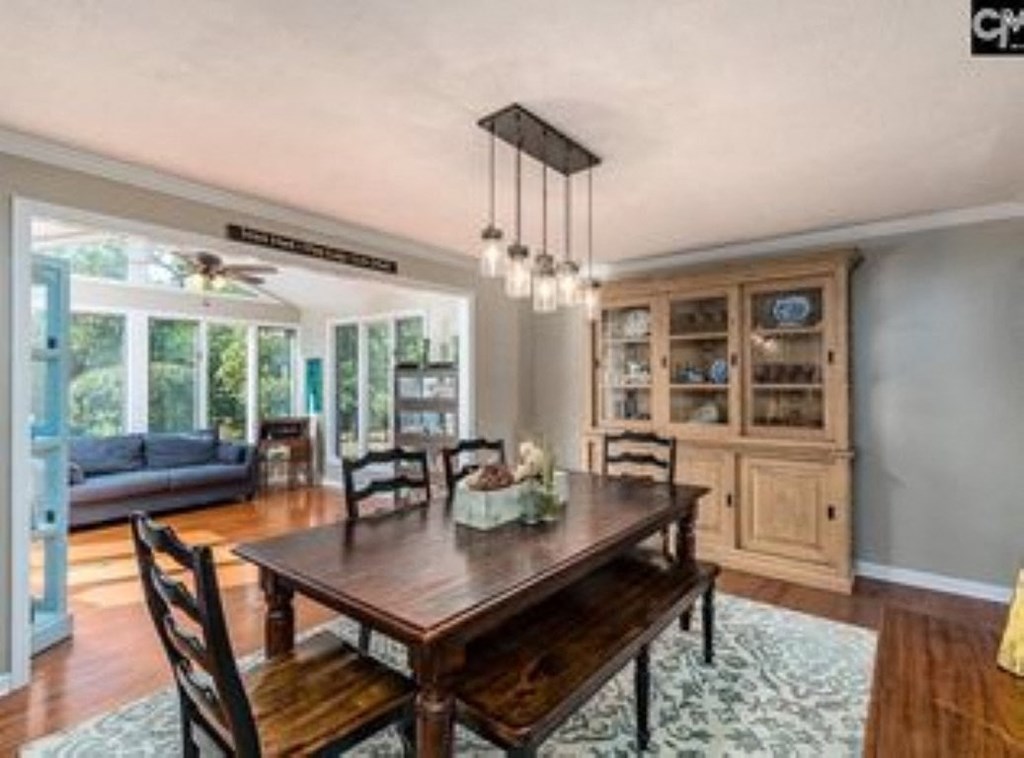 A dining room with a wooden table and chairs.