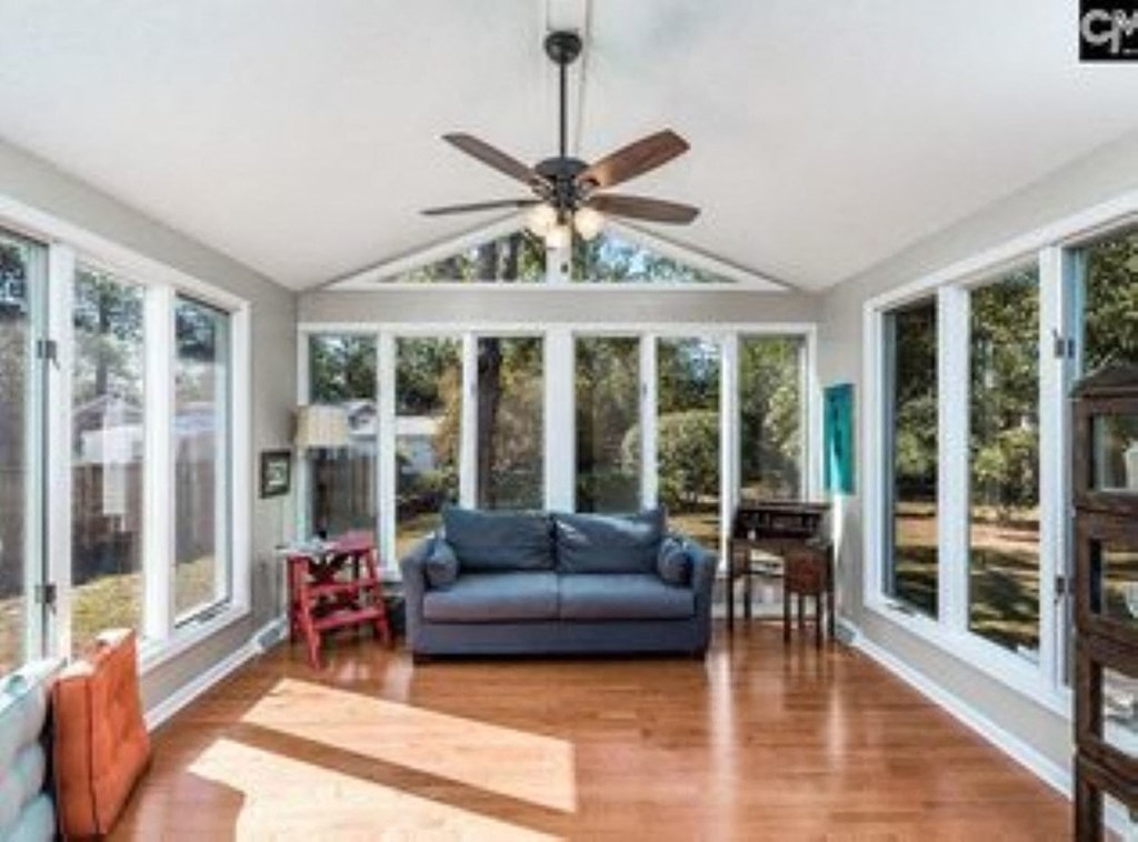 A sunroom with a ceiling fan and sliding glass doors.