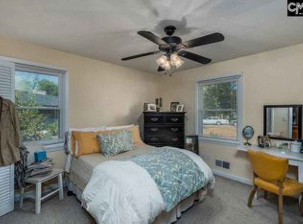 A bedroom with a bed, dresser, and chair.
