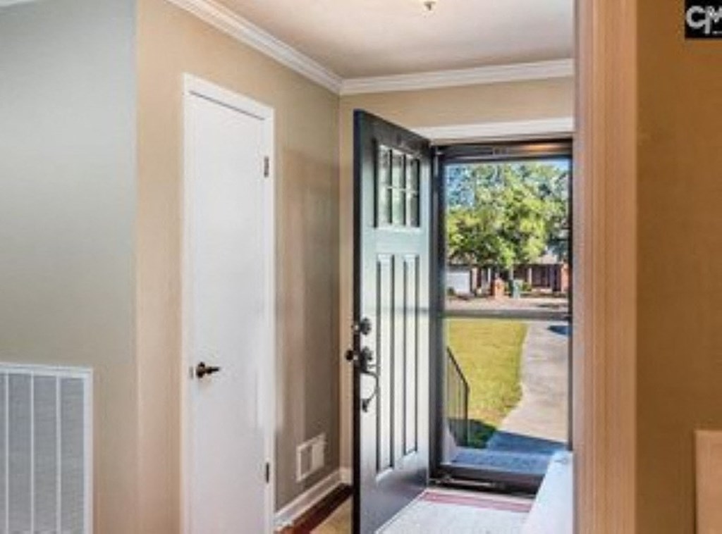 A white door is open to a balcony with a glass railing.