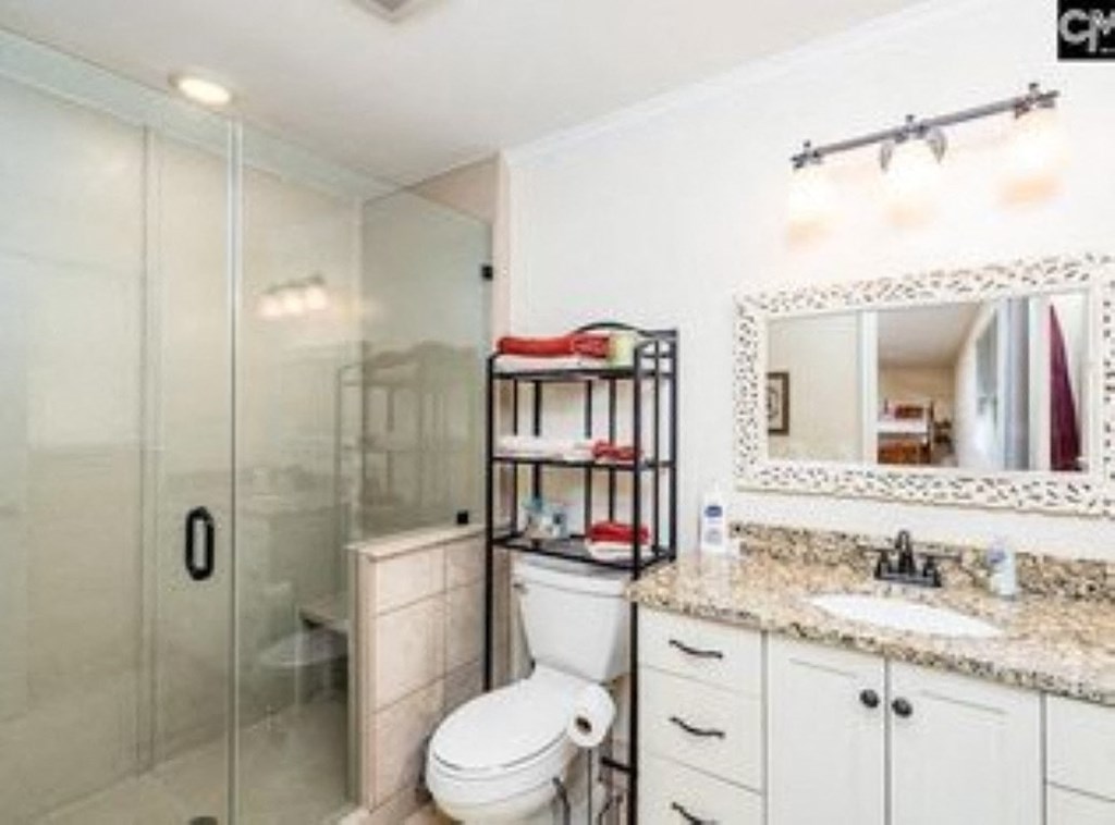 A white bathroom with a toilet, sink, and mirror.