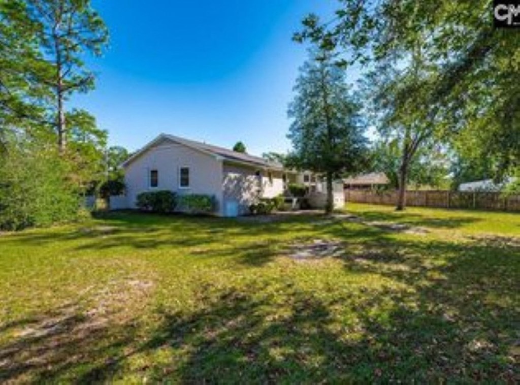 A white house with a green lawn in front of it.
