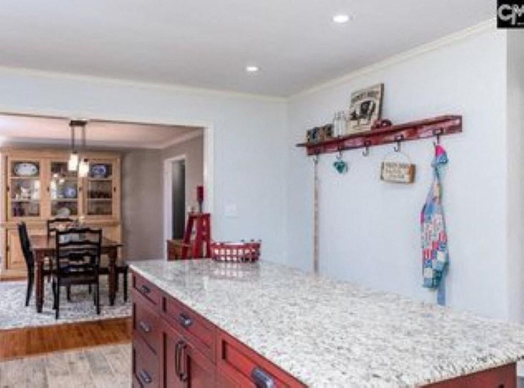A kitchen with a granite countertop and a dining table with chairs.