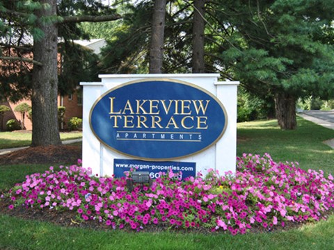a sign for lakeview terrace apartments in front of flowers