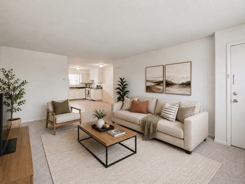A living room with a white couch, a wooden coffee table, and a painting on the wall.