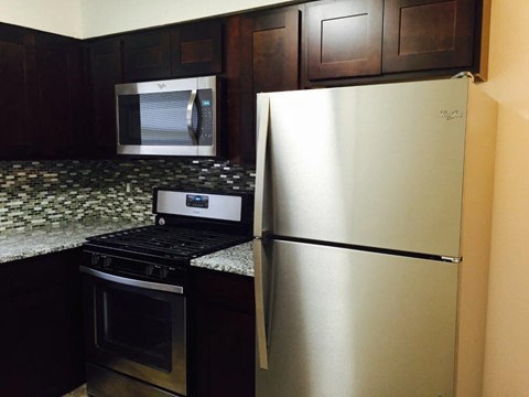 a kitchen with a stainless steel refrigerator and a stove