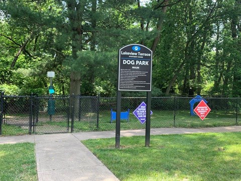 a dog park with a sign in the grass