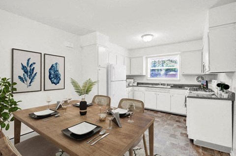a kitchen with white cabinets and a wooden table