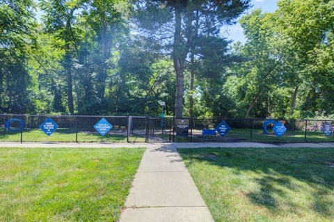 a dog park with a chain link fence and a sidewalk