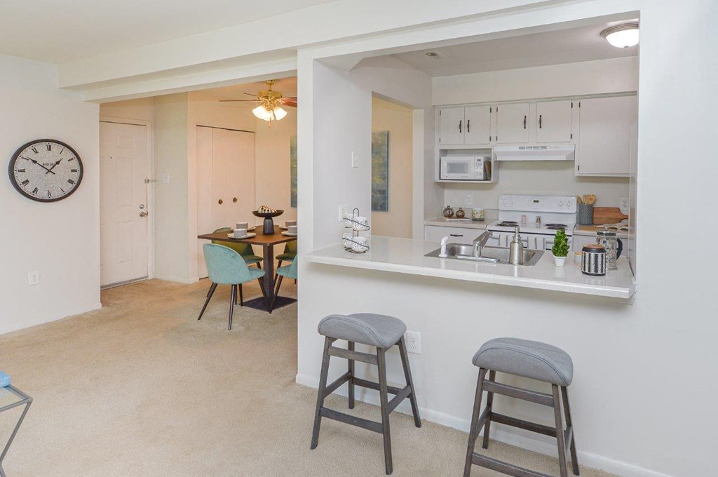 a kitchen and living room with a bar and a dining room