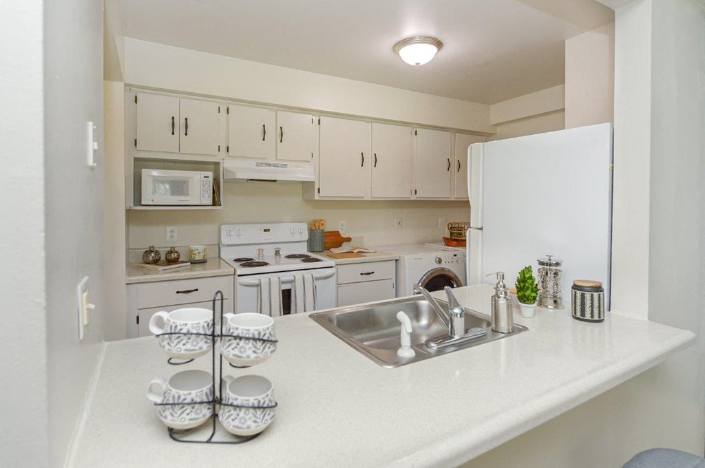 a white kitchen with white appliances and counter tops