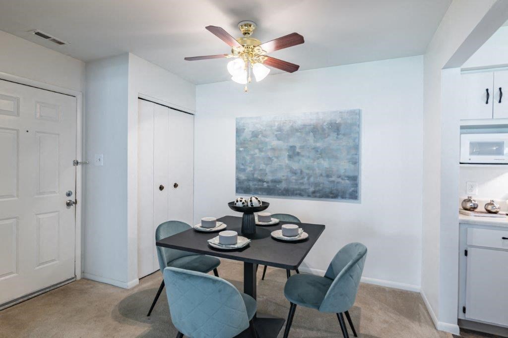 a dining room with a table and chairs and a ceiling fan