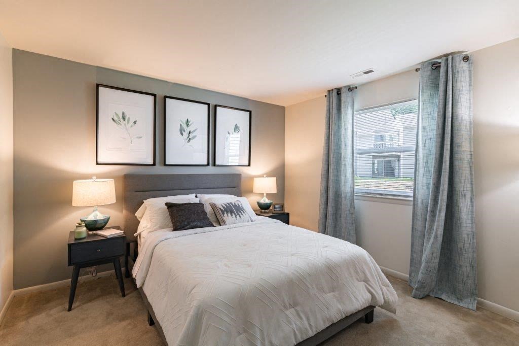 a bedroom with a bed and three pictures on the wall