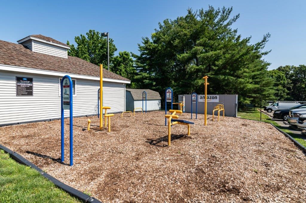 a playground in a yard with blue and yellow playground equipment