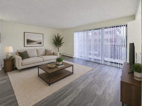 A living room with a couch, coffee table, and a painting on the wall.