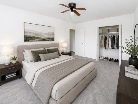 A bedroom with a large bed and a ceiling fan.
