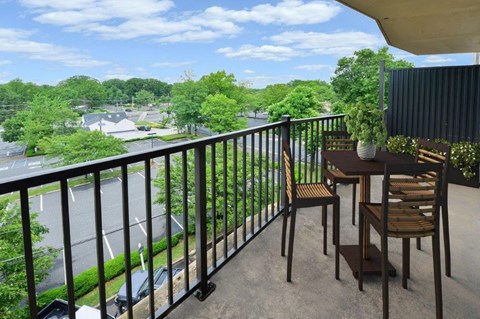 a balcony with a table and chairs on it