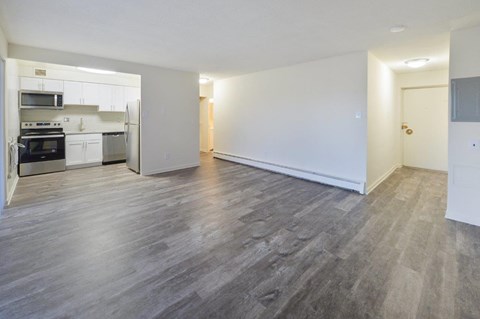 A spacious room with a grey floor and white walls.