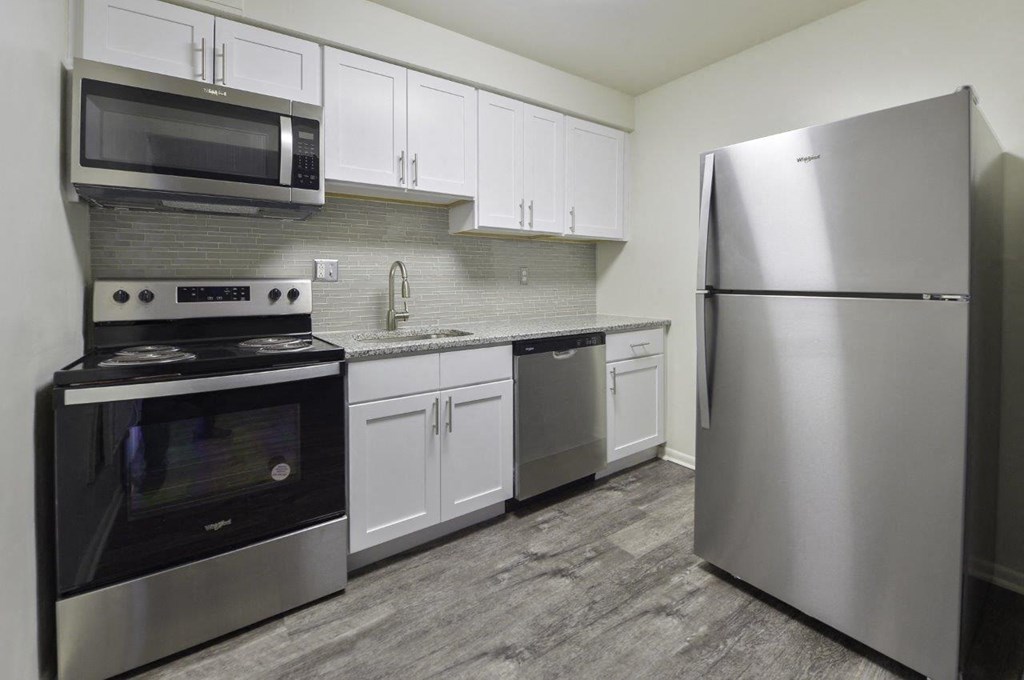 A modern kitchen with stainless steel appliances and white cabinets.