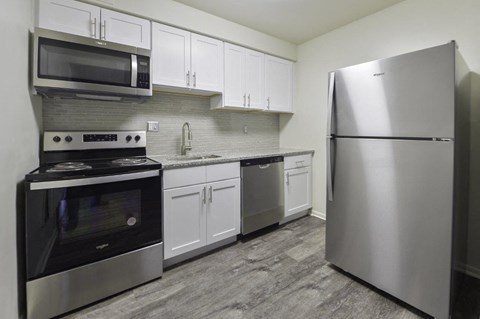 A modern kitchen with stainless steel appliances and white cabinets.