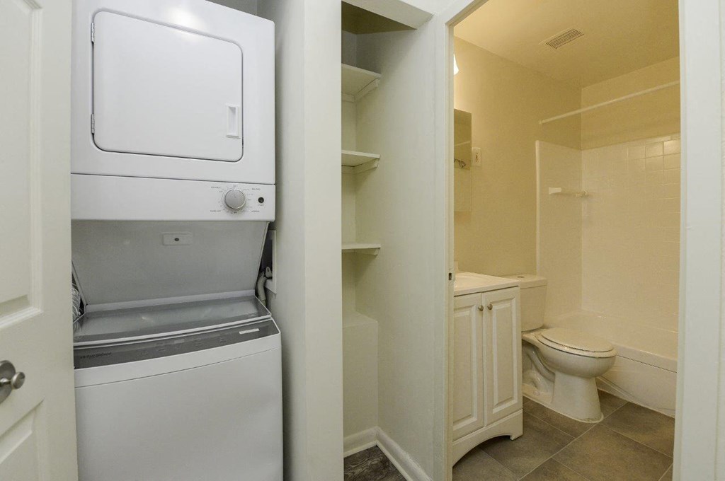 A white washing machine is in a small laundry room.
