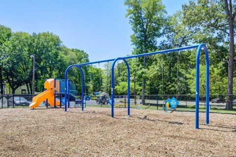a playground with a blue and orange swing set