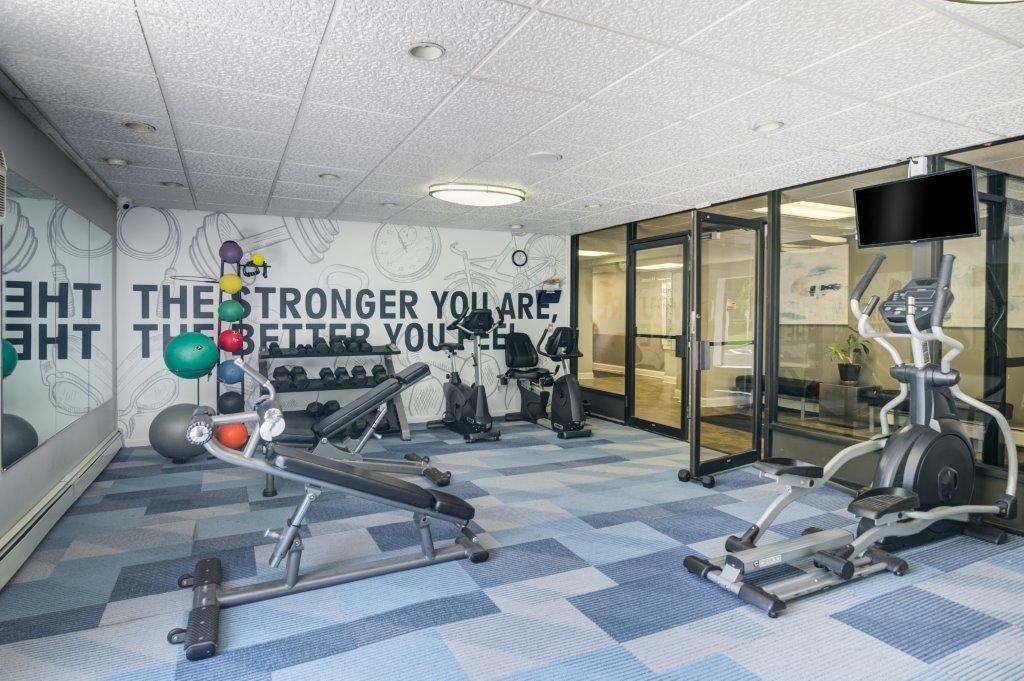 a workout room with weights and a tv