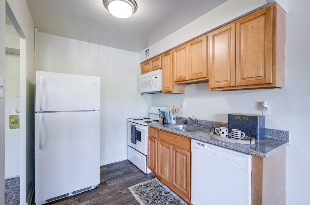 a kitchen with white appliances and wooden cabinets