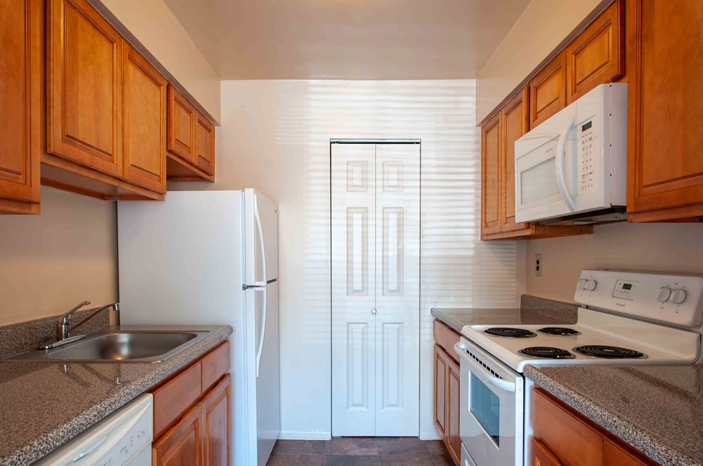 a kitchen with a stove refrigerator and sink