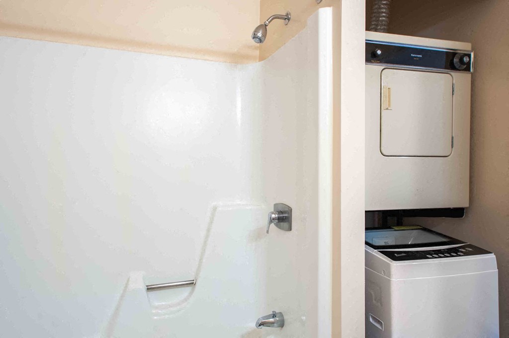a bathroom with a sink and a washer and dryer in it