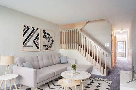 a living room with a couch and a staircase