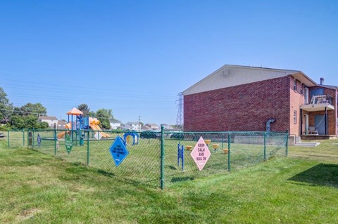 the playground is behind a chain link fence with flags on it
