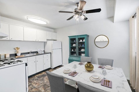 a kitchen with white cabinets and a table