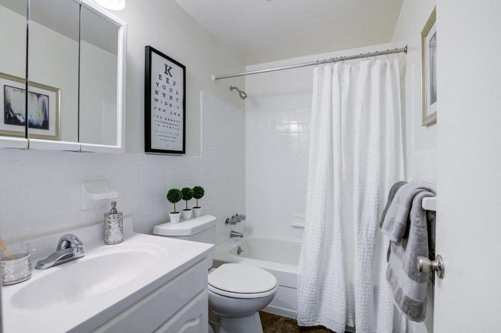 a white bathroom with a shower and a sink