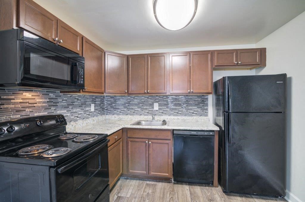a kitchen with black appliances and wooden cabinets