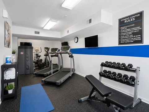 A gym with a sign that says "Fitness Center Rules".