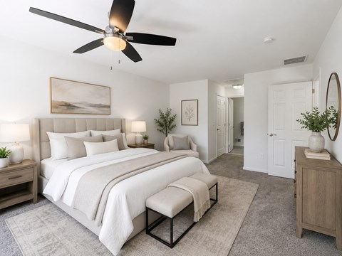 A bedroom with a large bed and a ceiling fan.