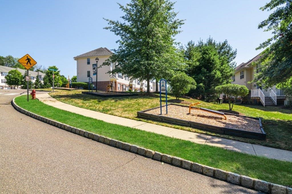 a playground on the side of a street in a neighborhood