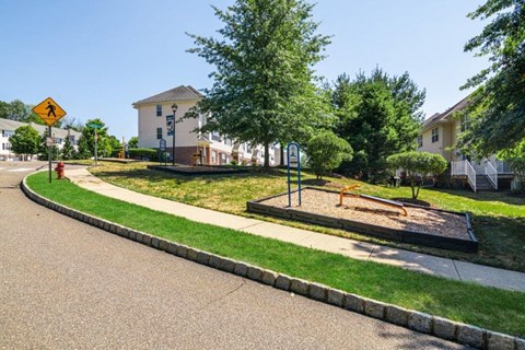 a playground on the side of a street in a neighborhood
