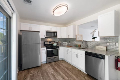 a kitchen with stainless steel appliances and white cabinets