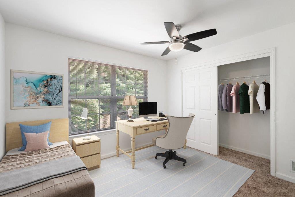 a bedroom with a desk and a ceiling fan