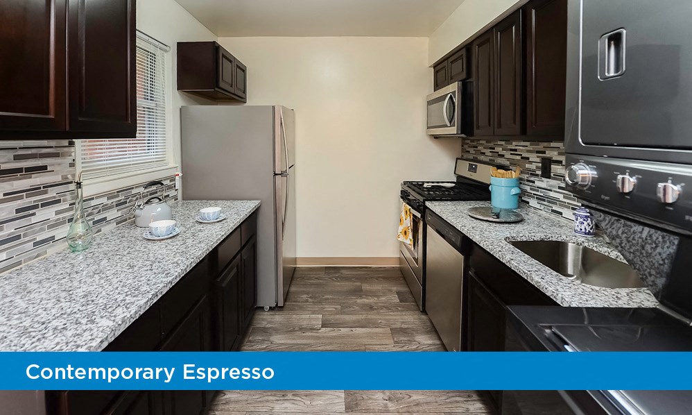 a kitchen with granite counter tops and a stainless steel refrigerator
