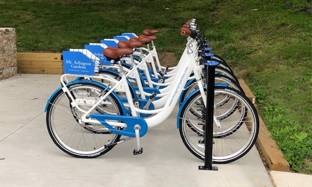 a row of blue and white bikes parked on a sidewalk