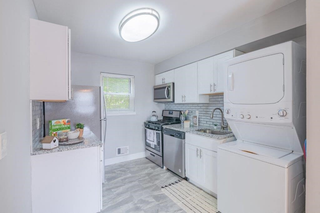 a white kitchen with white appliances and white cabinets