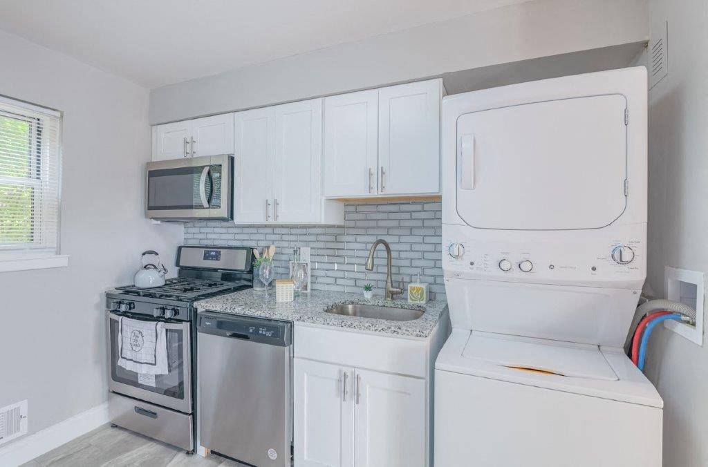 a white kitchen with a stove and a sink